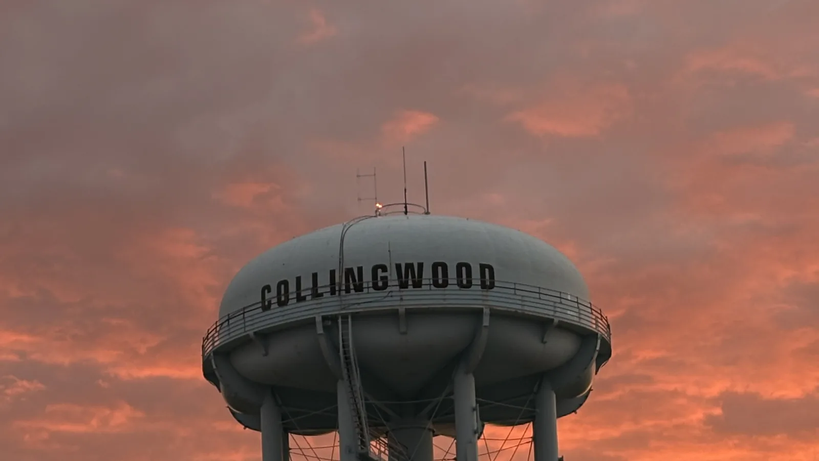 The Collingwood watertower silhouetted against a pink Georgian Bay sunset.