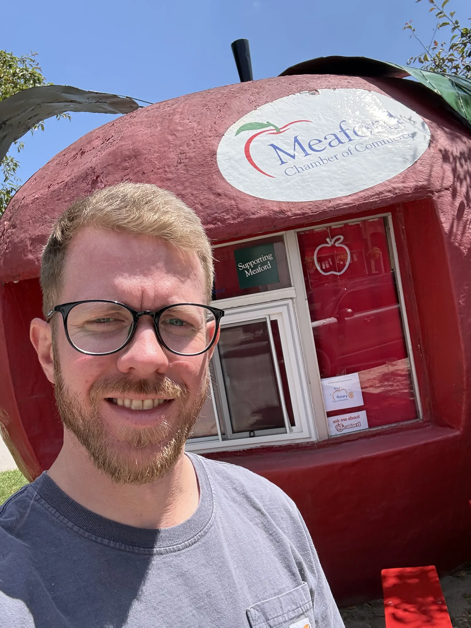Lasse from Georgian Bay SEO beside the giant red apple that houses the Meaford Chamber of Commerce information booth