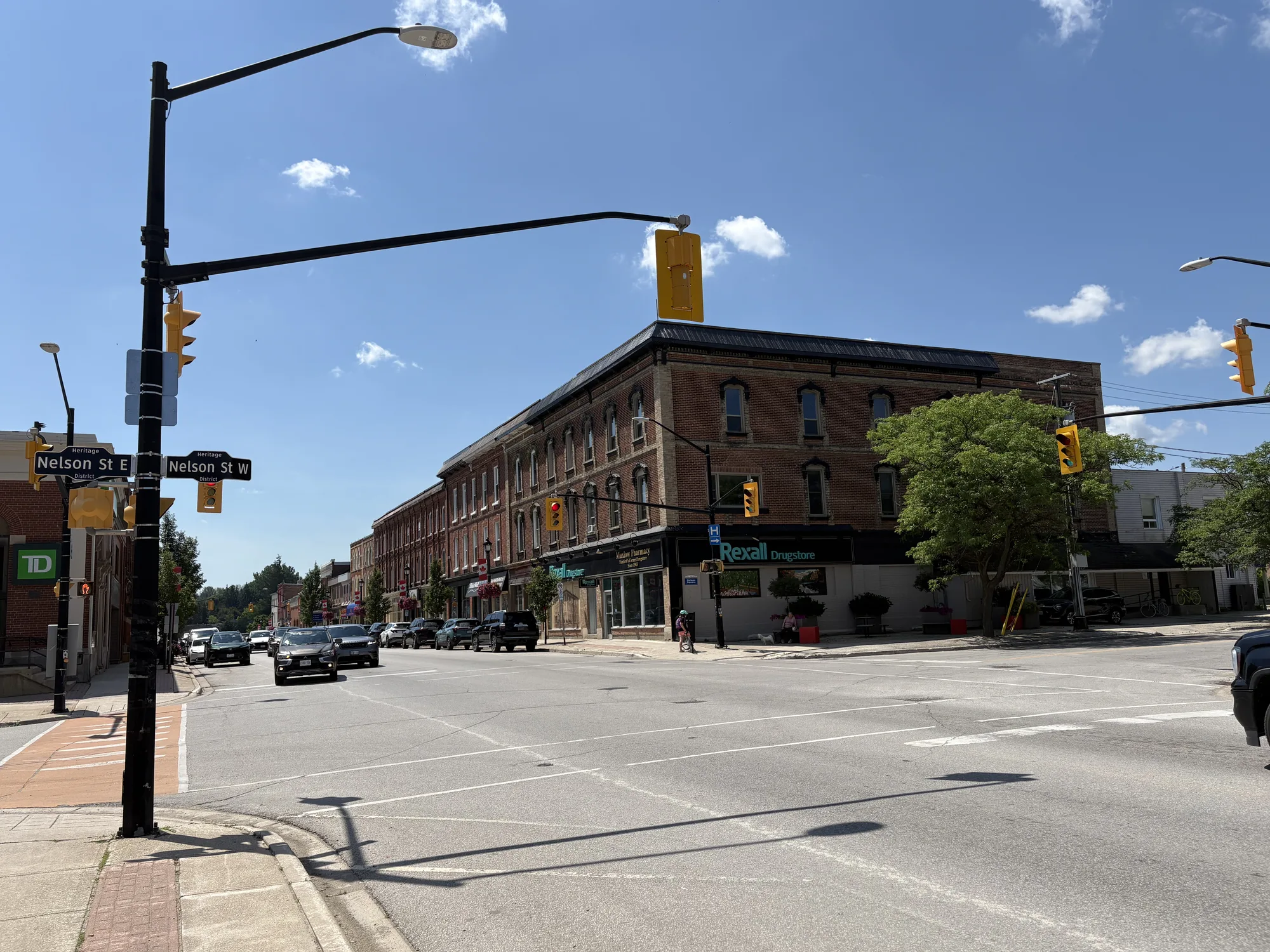 Downtown Meaford's main intersection with heritage brick storefronts under a summer sky