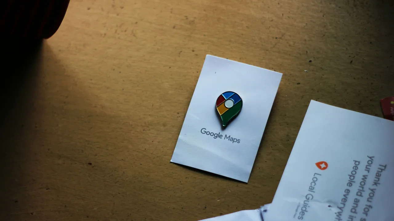 A Google Maps pin card on a desk.