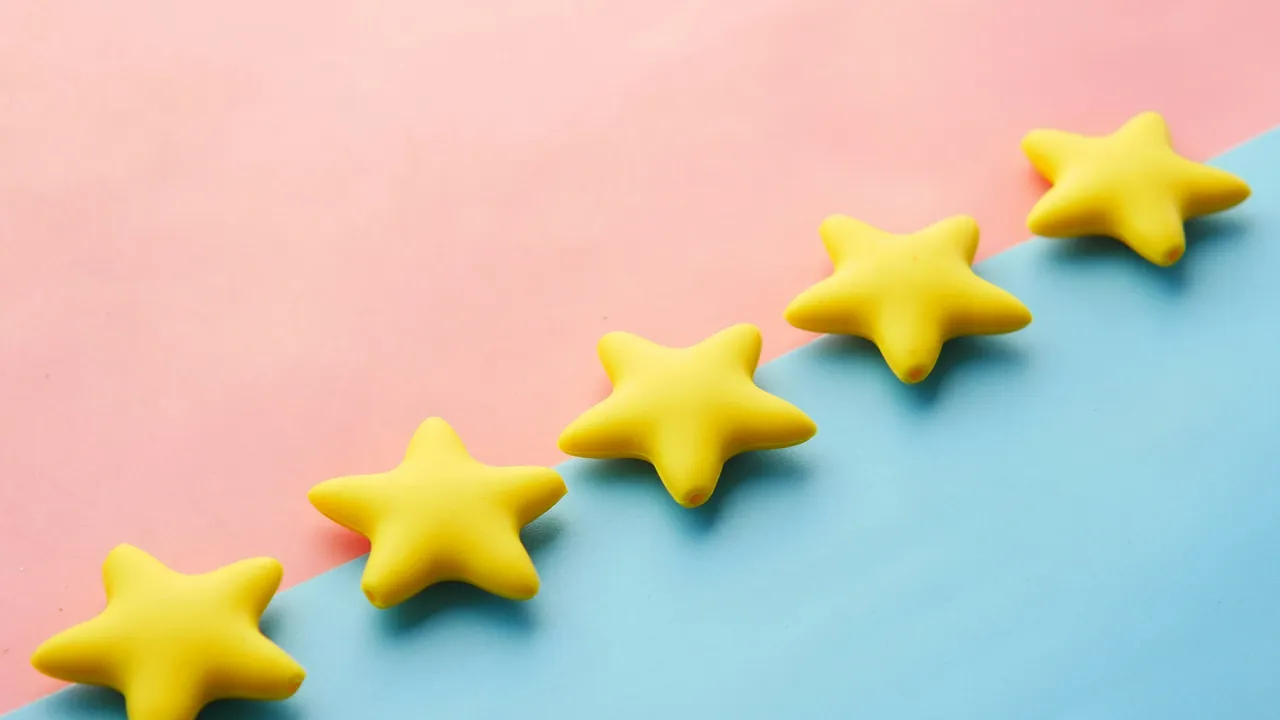 Five yellow stars in a row on a pink and blue background.